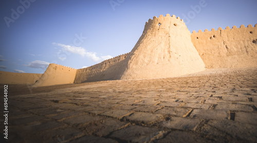 Tall ancient defensive fortifications made of bricks  clay and straw in the ancient fort city of Khiva in Khorezm  medieval architecture of the fortress at sunset