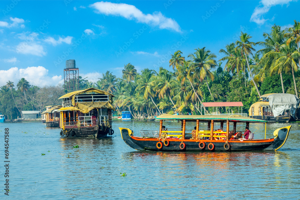 Indian traditional houseboats floating on Pamba river, with palms at the coastline, Alappuzha, Kerala, South India Indian traditional houseboats floating on Pamba river, with palms at the coastline, Alappuzha, Kerala, South India
