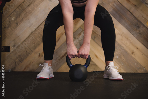 Woman Grasping Kettlebell to Begin Workout