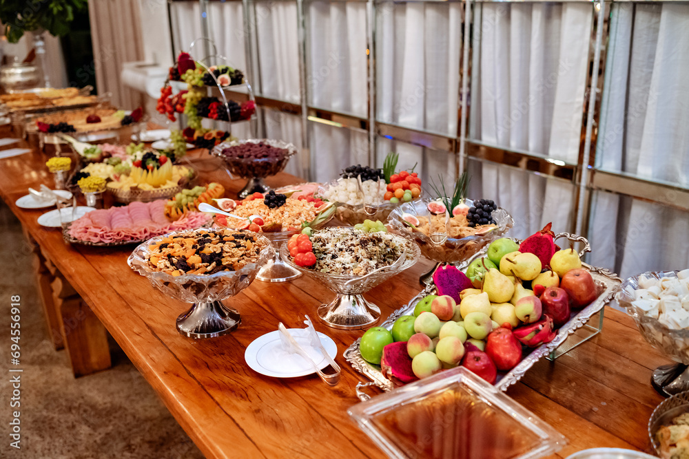 a buffet table decorated with fruits, meats and cheeses