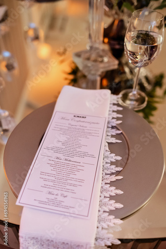 a round sousplat with a white napkin on top and a menu
