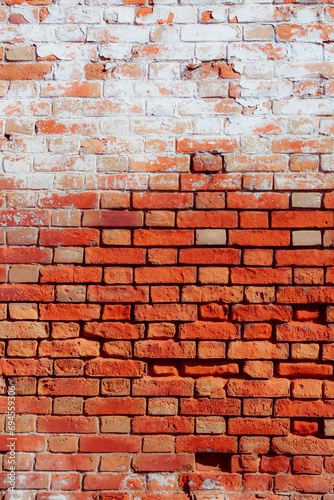 Old grungy red brick wall. Free space for an inscription. Can be used as a background or poster. Fragment of a wall with bumps and peeling paint.