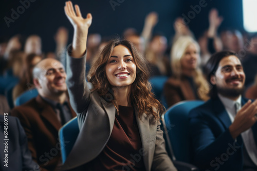 young businesswoman raises hand during audience question day photo