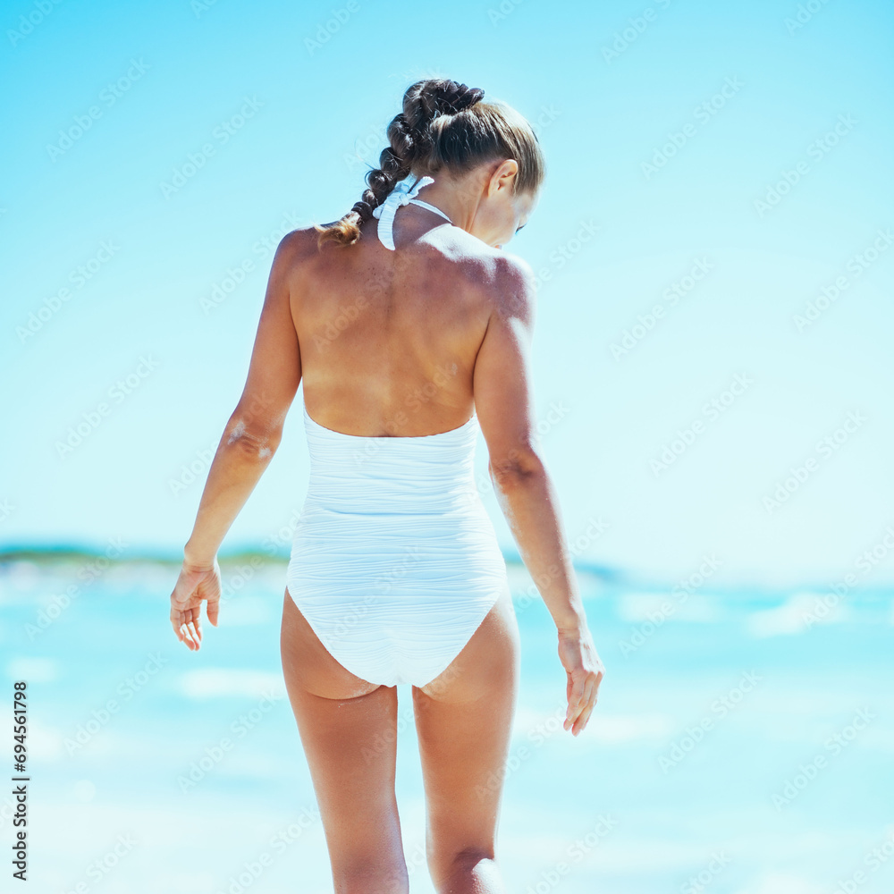 Young woman walking at seaside. rear view Young woman walking at seaside. rear view