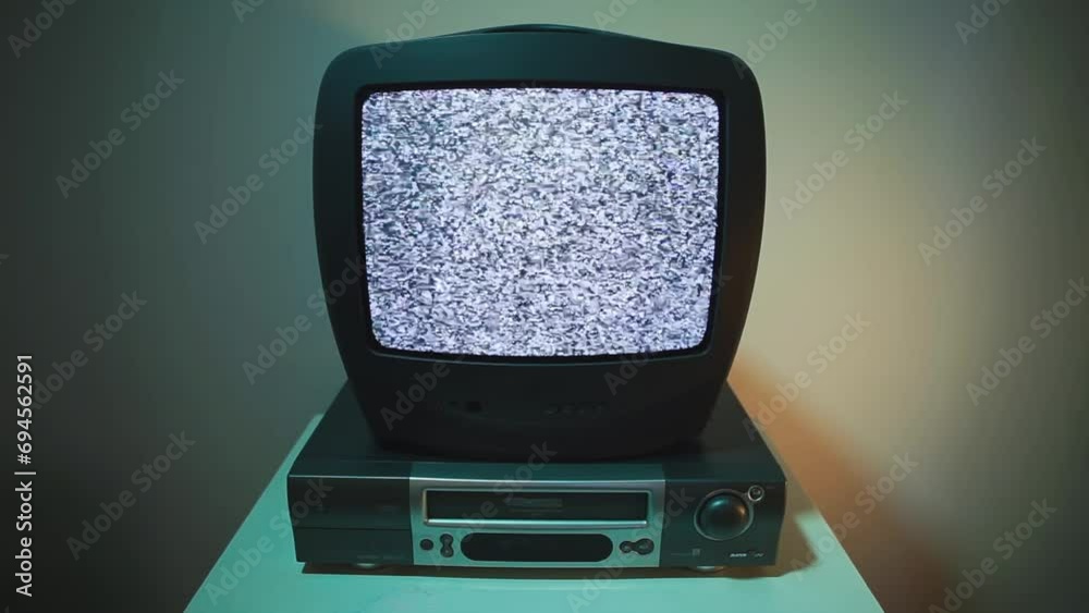 Old TV and VHS video recorder, a man inserts a cassette into the tape recorder