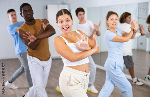 Happy multiracial men women of different ages performing dynamic energetic dancing movements in modern loft studio
