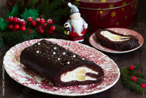 Obraz na płótnie Chocolate roll stuffed with butter cream and pineapple on a Christmas background. Rustic style. w salonie
