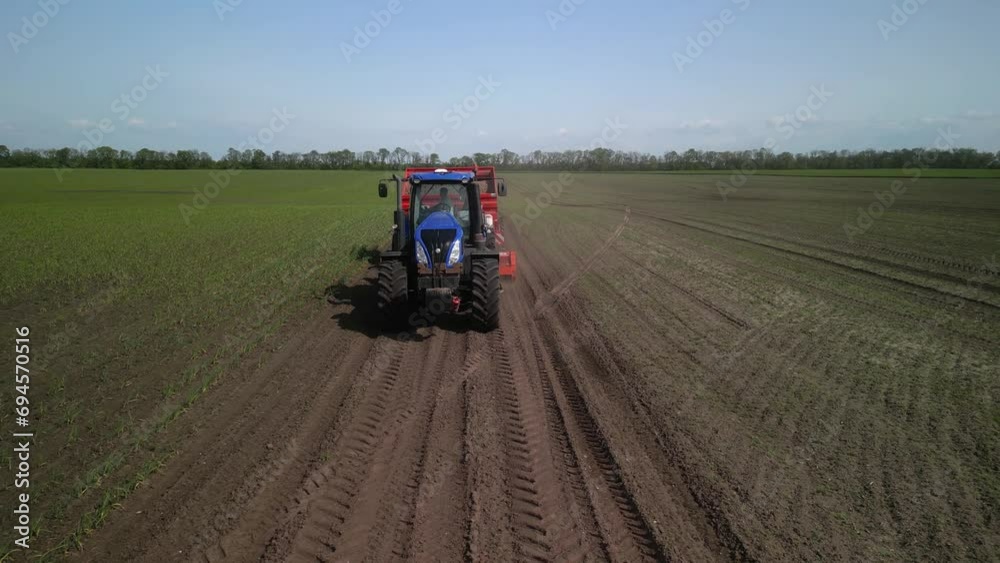 Blue Tractor planting potato on the field in Ukraine Blue Tractor planting potato on the field in Ukraine