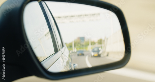 Side Rear View Mirror of a Driving Car