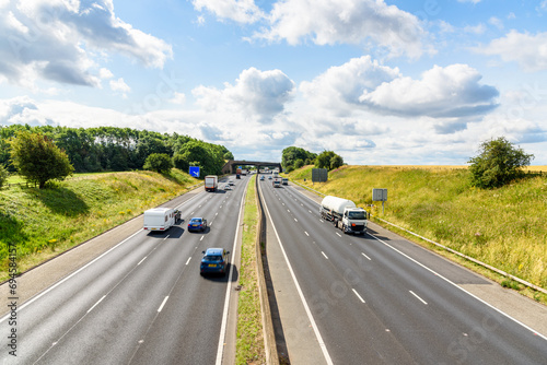 Traffic on a three-lane motorway through the English countryside on a sunny summer day photo