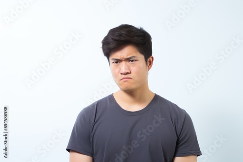 Confused Young Man with Frown on Plain Background. Generative AI.