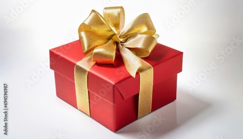 Red gift box wrapped with gold bow and ribbon isolated on white background. © adobedesigner