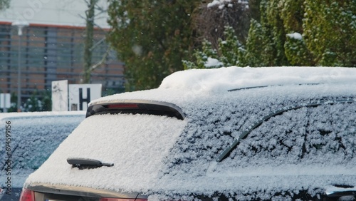 Car on Outdoor Parking Lot Covered in Fresh White Snow Falling on Cold Winter Day