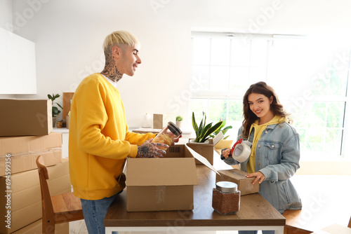 Young couple packing cardbo...