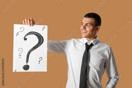 Young man holding paper wit...