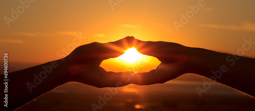 Young woman making a heart shape with her fingers on the beach. against the sunset.AI Generative 