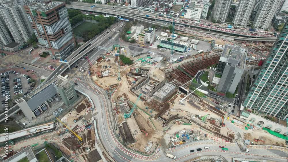 Multiple construction sites and ongoing tunnel and road infrastructure development amid high-rise buildings in an urban area.