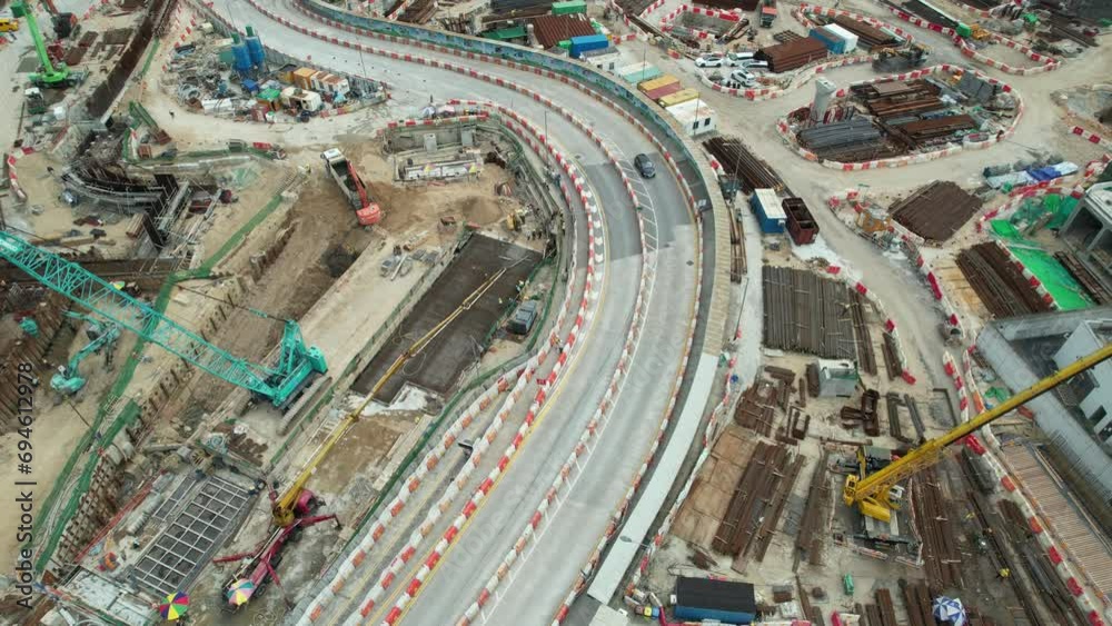 A construction site of the Central Kowloon Bypass Yau Ma Tei Interchange shows ongoing infrastructure development, with cranes, construction materials, and partially completed roadways surrounding excavated areas.