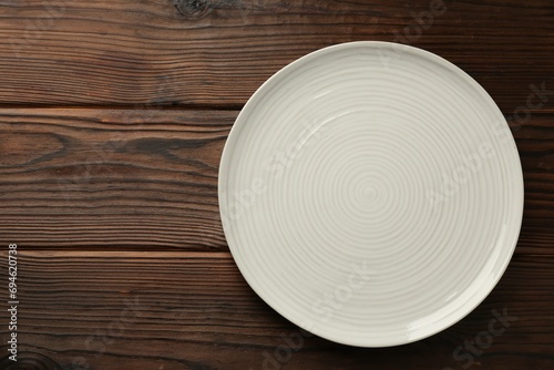 Beautiful ceramic plate on wooden table, top view. Space for text