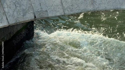 Seething water under the bridge. City river.