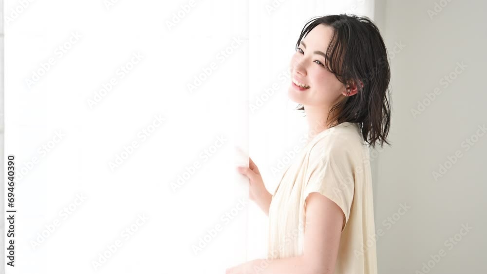 Young woman standing by a window Video of a smiling profile Young woman standing by a window Video of a smiling profile