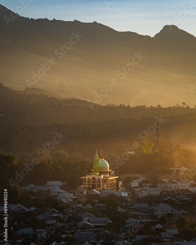 Sunset over the village of Sambaloen. Golden hour. Mosque in the foreground. Around the buildings. Lombok. Indonesia