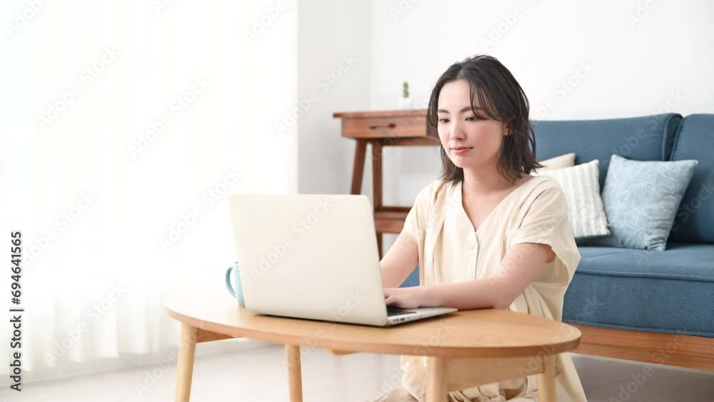 Video of a young woman using a computer in her living room Video of a young woman using a computer in her living room