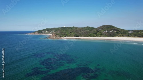 The Pass And Clarkes Beach On Byron Bay In New South Wales, Australia. Cape Byron Lighthouse In Distance. aerial pullback photo