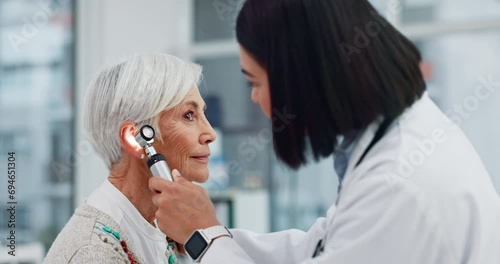 Senior woman, doctor and otoscope for ear, hearing test and exam, audio check or consultation for healthcare. Ent, otolaryngology and medical professional with elderly person for wellness in hospital photo