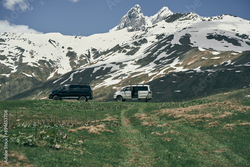 Mountain Ushba in Svaneti, Georgia. Two cars, double summit on the background 