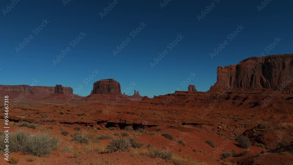 Monument Valley in Utah and Arizona. Driving along red rock formations in iconic scenic wild west landscape.