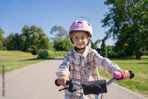 Cheerful child rides on a Bicycle in city park outdoor. 