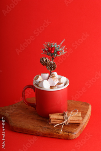 Red mug full of hot chocolate and marshmallows on an isolated red background, new year and christmas theme