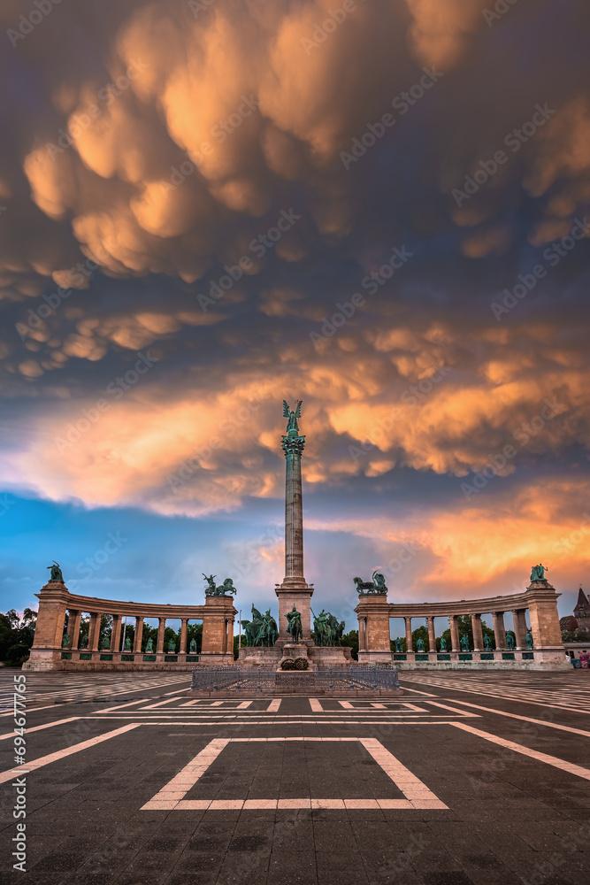 Fototapeta premium Budapest, Hungary - Unique mammatus clouds over Heroes' Square Millennium Monument at Budapest after a heavy thunderstorm on a summer afternoon sunset with warm golden colors