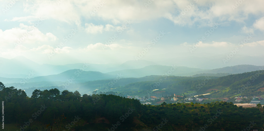 Obraz premium Aerial view of Dalat city in the morning mist with sun light through the blue sky