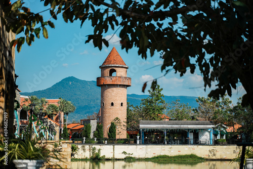 An ancient tower standing on the water's edge, a tourist attraction with traditional Western buildings.