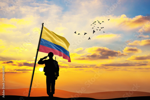 Silhouette of a soldier with the Colombia flag stands against the background of a sunset or sunrise. Concept of national holidays. Commemoration Day.