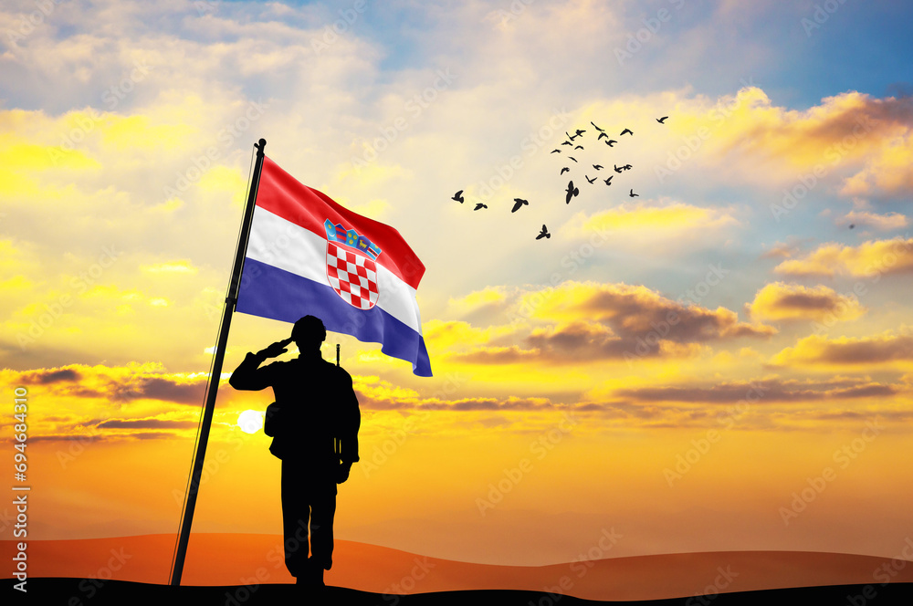 Silhouette of a soldier with the Croatia flag stands against the background of a sunset or sunrise. Concept of national holidays. Commemoration Day.