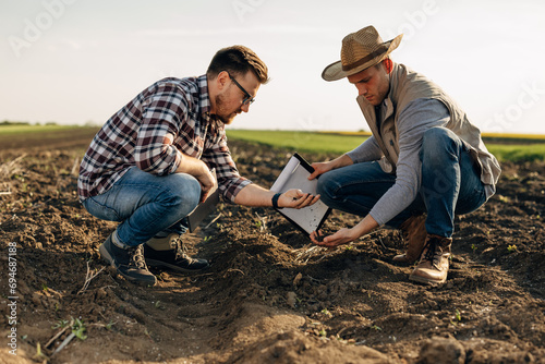 Agronomists are inspecting the quality of soil in the field.