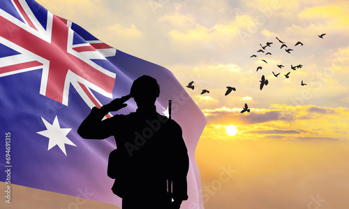 Silhouette of a soldier with the Australia flag stands against the background of a sunset or sunrise. Concept of national holidays. Commemoration Day. photo