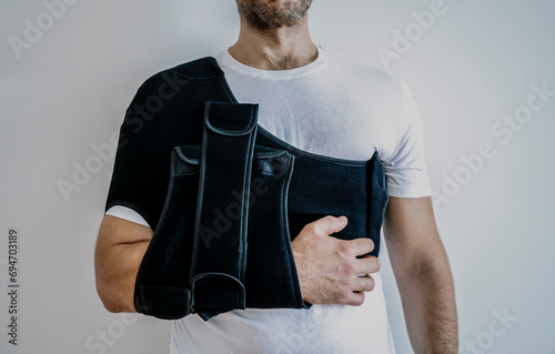 Shoulder orthosis orthoses orthopedic medical recovery sling for support hand background. photo