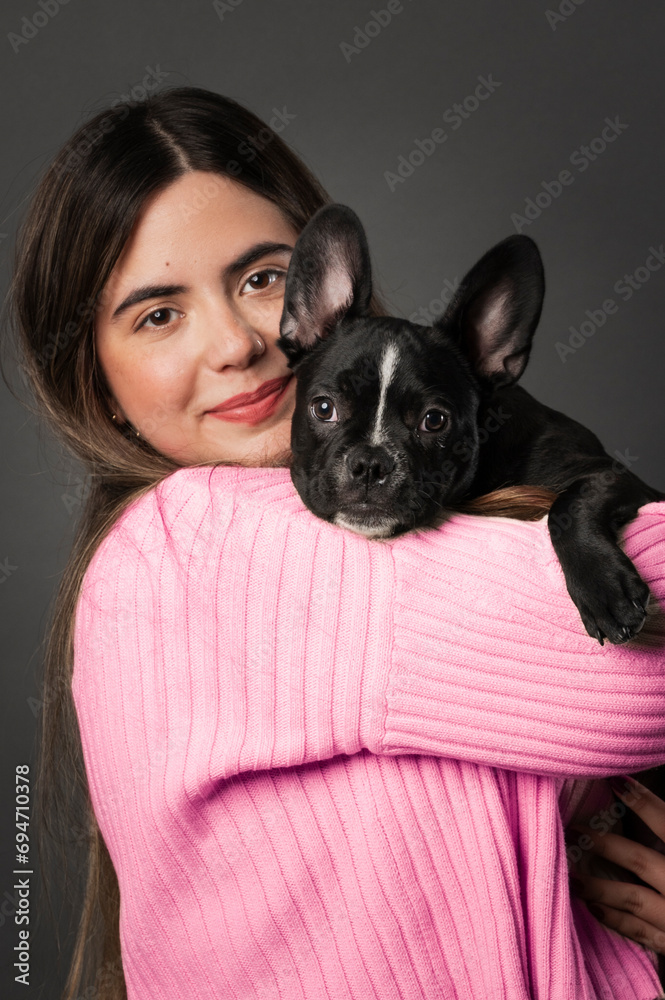 Young Latin white woman with a small French bulldog purebred puppy