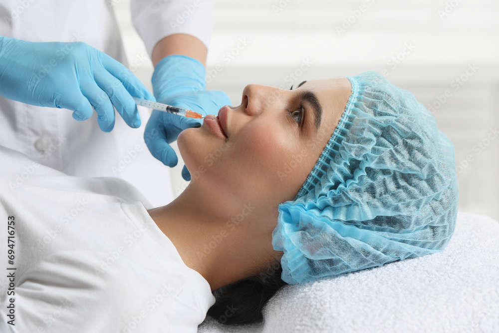 Doctor giving lips injection to young woman in clinic. Cosmetic surgery Doctor giving lips injection to young woman in clinic. Cosmetic surgery