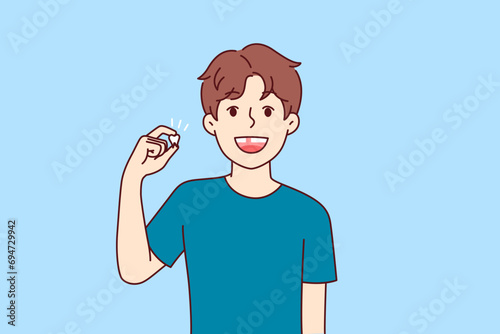 Happy kid demonstrates lost baby tooth and smiles, rejoicing at beginning of growing up. Positive pre-teen boy is waiting for tooth fairy to give him gift, for advertising dentist clinic.