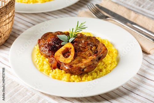 Italian dish Ossobuco meat, specialty of Lombard cuisine of cross-cut beef shanks braised with onion, white wine, and broth. Served with risotto alla milanese, rise made with saffron and cheese.