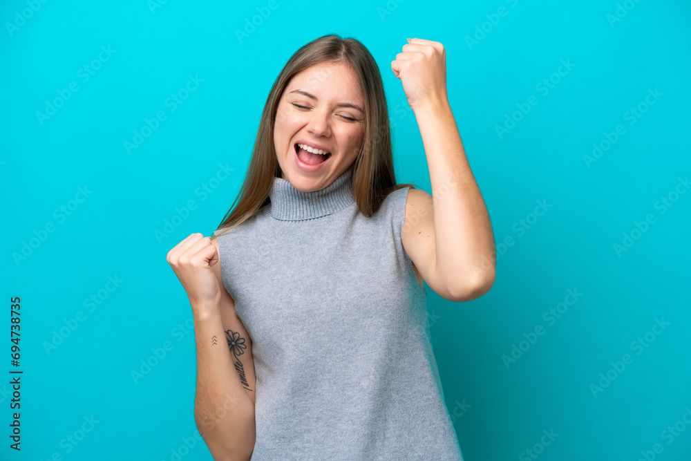 Young Lithuanian woman isolated on blue background celebrating a victory - obrazy, fototapety, plakaty 