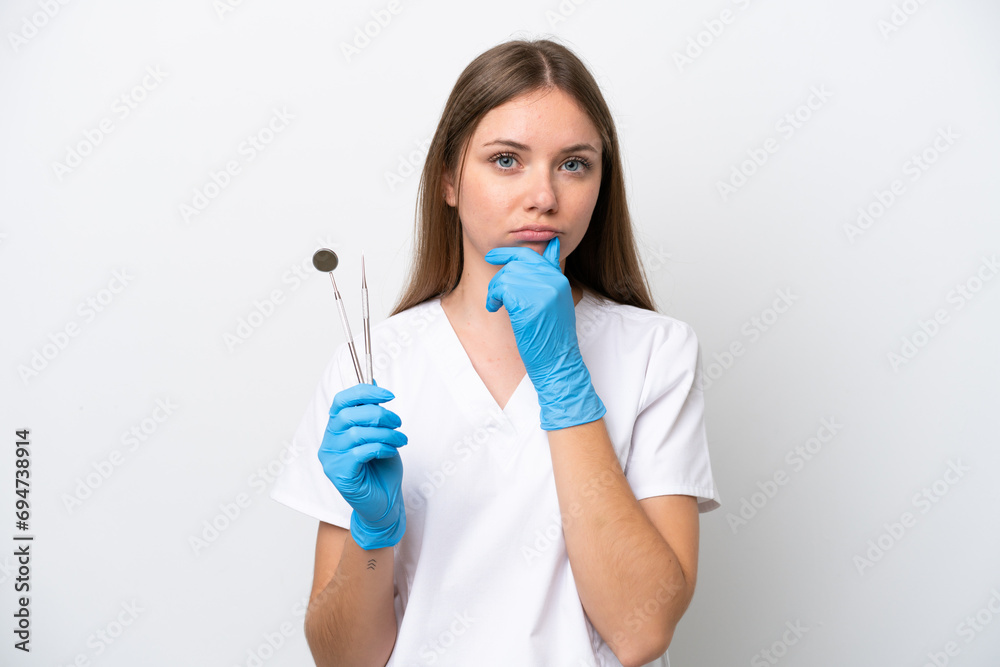 Dentist woman holding tools isolated on white background thinking Dentist woman holding tools isolated on white background thinking