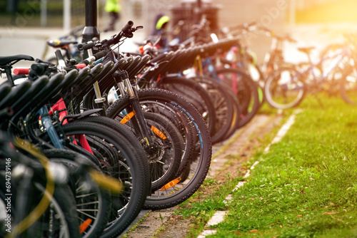 Bikes of different styles and colors lined up in a parking lot in the urban streets of a European destination for tourists and cyclists.