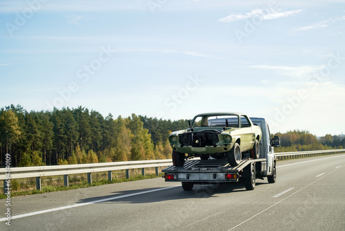 Wallpaper Mural Roadside assistance transports a car with a breakdown on the road. Rollback tow truck. A tow truck delivers a failed vehicle. Roadside assistance helps a driver in trouble. Torontodigital.ca