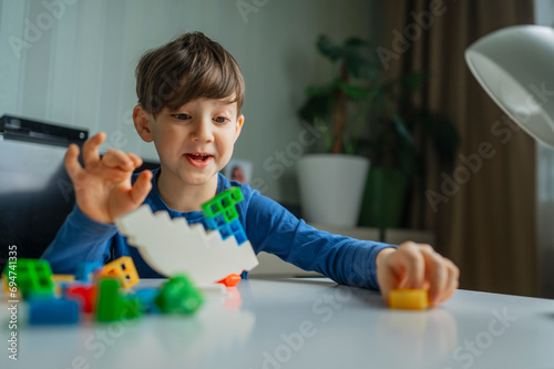 Happy boy playing with toy blocks at home photo